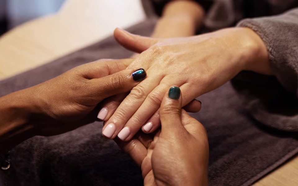 Manicure in progress with hand care and polished nails